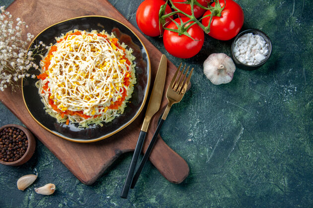 烹饪顶视图美味含羞草沙拉在盘子里与深蓝色背景上的红色西红柿番茄晚餐食物