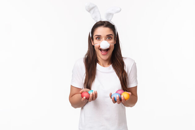 商业肖像富有表现力的年轻女子戴着兔子的耳朵和鼻子 手里拿着彩蛋时尚折扣快乐