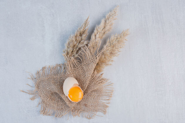 蛋壳蛋黄在一块破壳上放在一块布上放在大理石桌上美味生的鸡蛋