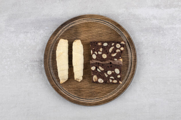 甜点石头桌上放着一盘传统的甜木塔基和可可饼干健康面包卷烘焙