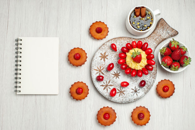 甜点俯瞰白色桌子上的奶油蛋糕和水果蛋糕水果花茶