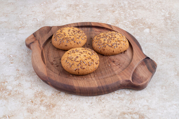 甜点石头桌上放着一盘带种子的美味饼干烘焙燕麦片健康小吃