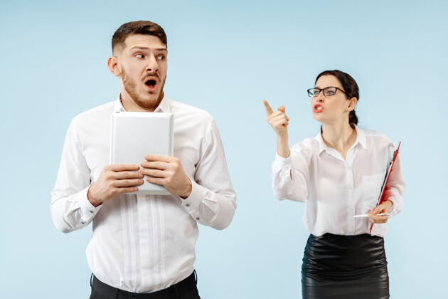 情绪愤怒的老板女人和他的秘书站在办公室或工作室女商人对他的同事尖叫女人电脑公司