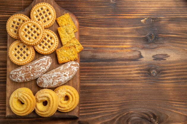 容器俯瞰棕色木桌上不同的饼干和茶点雕刻贝壳木头