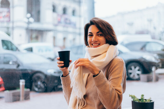 冬天一个女孩在舒适的咖啡馆里用一杯热咖啡取暖肖像女人秋天