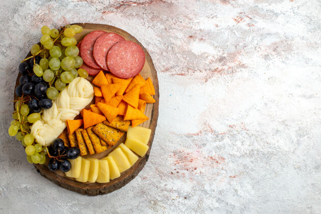 不同俯瞰不同的小吃cips香肠奶酪和新鲜葡萄的白色空间葡萄生的顶部