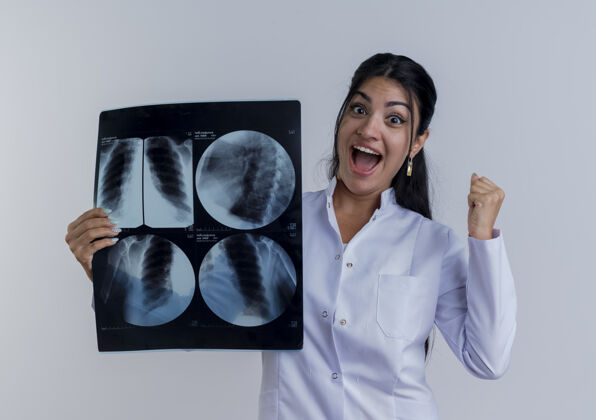 年轻人快乐的年轻女医生穿着医用长袍拿着x光片看着做是的手势孤立镜头X光医生