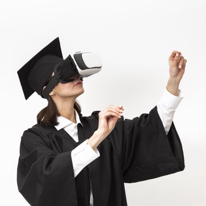 虚拟现实眼镜穿着毕业礼服戴毕业帽戴着虚拟现实耳机的女人毕业帽毕业仿真