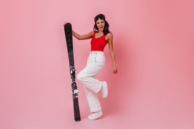 配件一个穿着白裤子拿着滑雪板的女人成人时尚运动