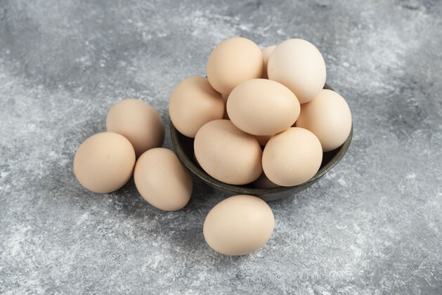 美味在大理石上放一碗新鲜的生鸡蛋鸡蛋自然菜肴