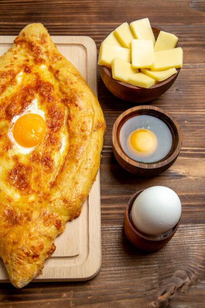 烹饪顶视图新鲜烤面包配熟鸡蛋放在棕色木制书桌上面团餐包早餐鸡蛋食品新鲜顶部书桌