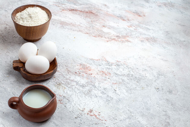 生的正面图全生鸡蛋配面粉和牛奶 背景为浅白色鸡蛋生早餐餐食品咖啡早餐