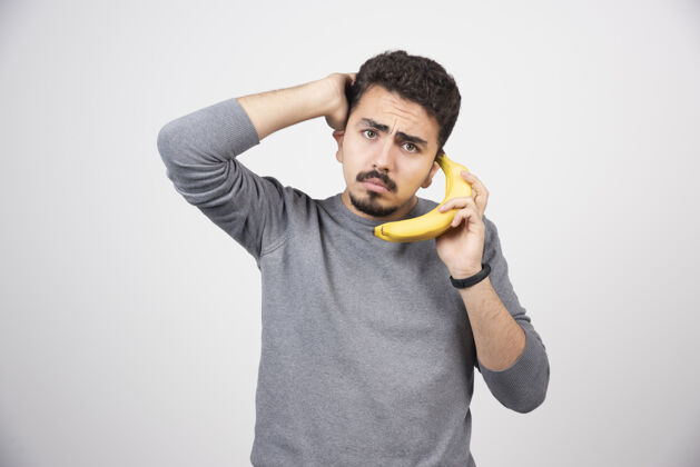 指向一个拿着香蕉当手机的年轻模特儿男性人情绪