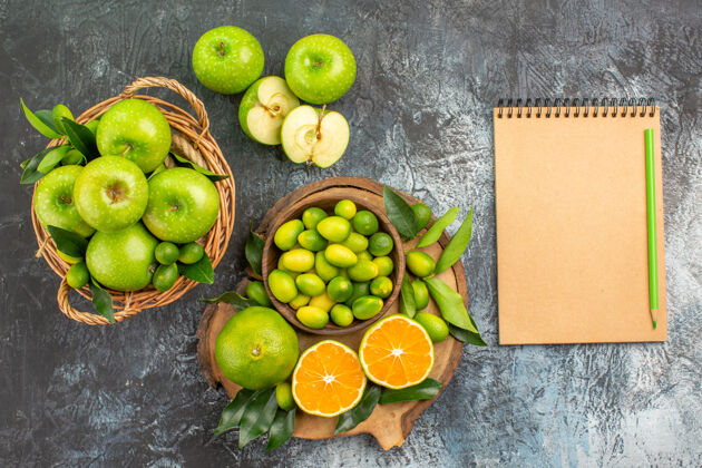 吃苹果顶部特写查看苹果与柑橘水果篮子苹果笔记本铅笔板特写食物酸橙
