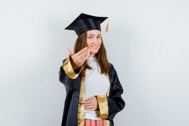 帽子女毕业生身着学院服 喜气洋洋地前来参观的画像毕业典礼人民