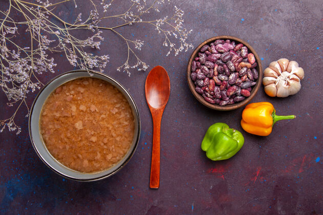 胡椒顶视图褐色的汤在盘子里用豆子放在深色的表面上汤菜饭菜菜油汤油烹饪