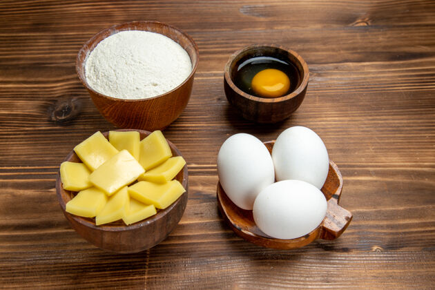 餐正面图：棕色木桌上全生鸡蛋加奶酪粉产品蛋面团糕点早餐风景潘趣酒