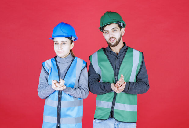 人男性和女性工程师戴着头盔 摆出冷静和中立的姿势姿势员工人