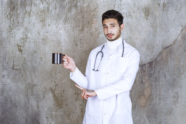 姿势男医生拿着听诊器端着一杯咖啡药休息医疗