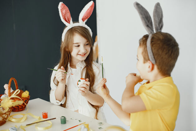 兔子有兔子耳朵的孩子彩蛋有颜料和刷子的孩子房子复活节家庭