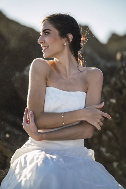 垂直身穿白色连衣裙的黑发女性 带着真诚的微笑海岸线太阳海岸