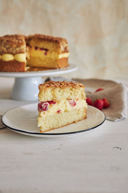 食物垂直特写镜头美味的香草奶油蛋糕与草莓内的白色桌子上块水果蛋糕