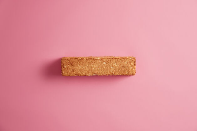 硬皮白色面包吐司 有开胃的面包皮 从上面拍摄 隔离在玫瑰色的背景上一片谷物面包美味可口的早餐小吃和食物适当的营养概念传统面团烘焙