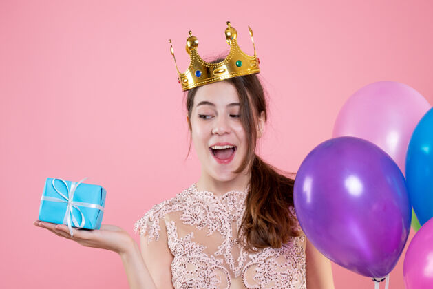 礼物特写前视图可爱的聚会女孩与皇冠举行的礼物和气球微笑皇冠粉红色