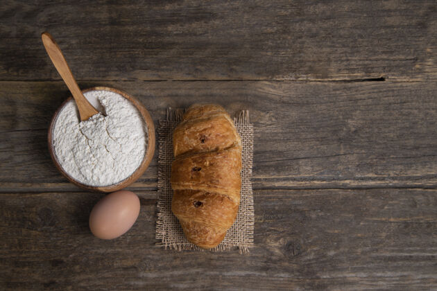 面粉新鲜出炉的羊角面包配上鸡蛋和面粉高品质照片面包卷鸡蛋美味