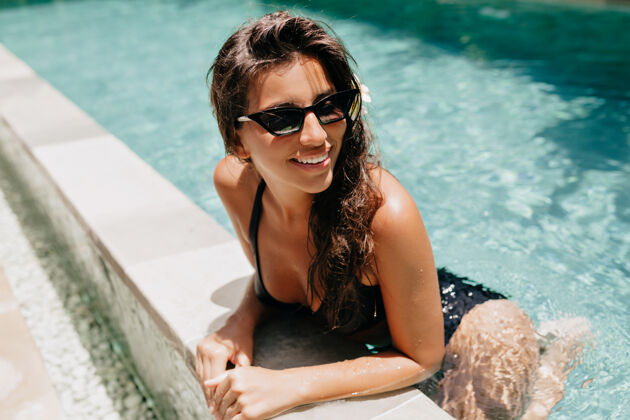 年轻在阳光明媚的温暖日子里 可爱可爱的黑发女士在游泳池里嬉戏的外景写真暮色孤独感官