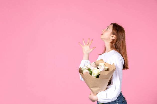 人正面图：年轻女性 带花朵 作为女性节礼物 粉色背景 横向 女性三月 爱情 性感 日期平等 玫瑰色花玫瑰年轻的女性