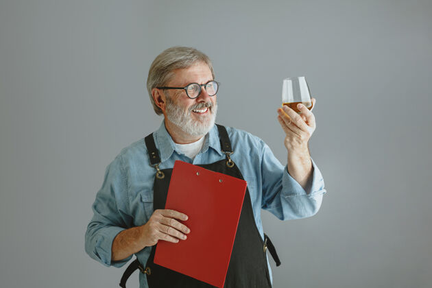 人自信的高级酿酒师 在灰色的木桶上 用玻璃瓶自制啤酒工厂职业技术