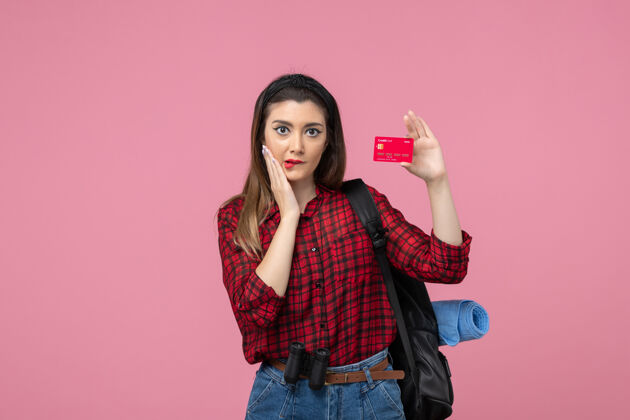 脸正面图身穿红色衬衫的年轻女性 背景为粉色的银行卡 女性颜色为人类女士肖像衣服