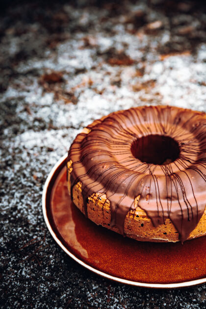 蛋糕白色陶瓷盘上的棕色圆蛋糕螺旋穆迪冬天