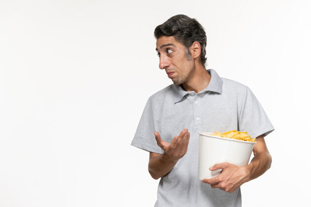孤独正面图：年轻男性手提篮 白色表面上放着薯片电影前面篮子
