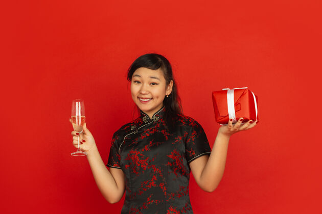 庆祝年轻的亚洲女人喝香槟拿着礼物服饰美丽祝福