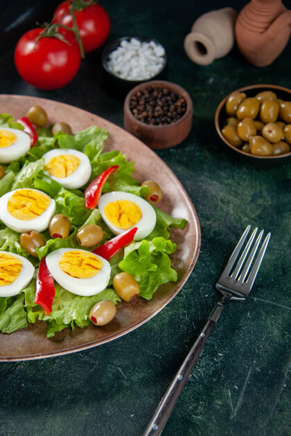 橄榄正面图美味的鸡蛋沙拉由绿色沙拉和橄榄色背景组成盘子封闭沙拉