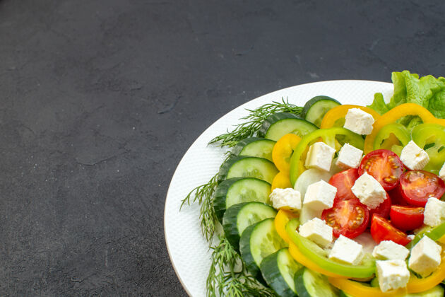 沙拉前视图蔬菜沙拉由切片黄瓜 西红柿 胡椒和奶酪组成 背景为深色胡椒黄瓜背景
