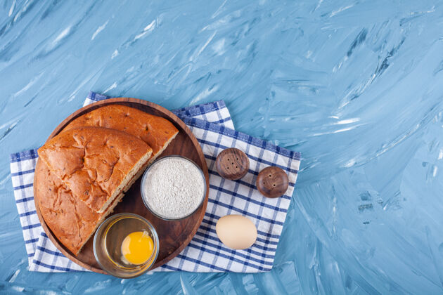 小面包蓝色表面上放着切片面包 蛋黄和面粉的木盘食物小吃美味