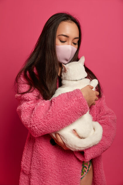 健康戴着防护面具的年轻美女抱着一只猫的特写镜头民族脸过敏