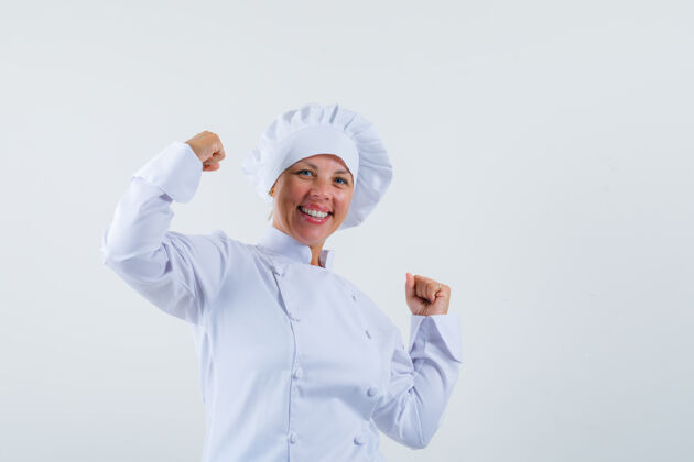 优胜者身着白色制服的女厨师摆出赢家的姿态 看上去很高兴女人魅力时尚