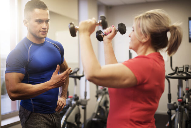 帮助成熟的女人和教练一起锻炼教练肌肉建设运动训练