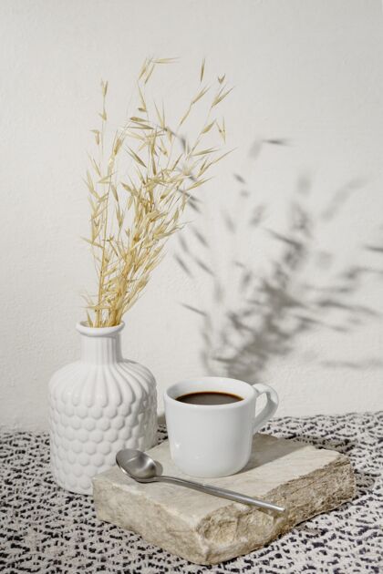 杯子花瓶里放着干小麦和一杯咖啡花瓶影子小麦