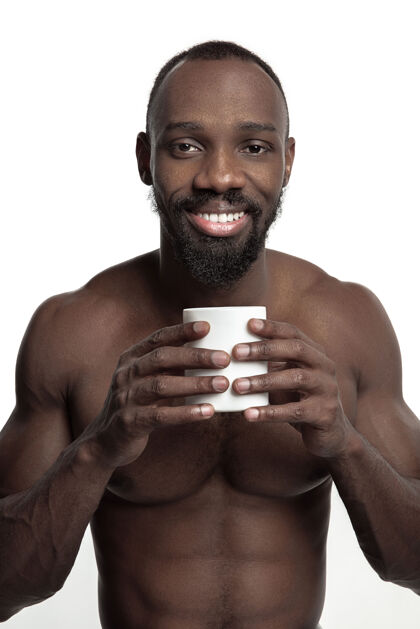 民族一个非洲男人 喝着一杯白色的茶或咖啡 在白色的工作室里与世隔绝站立杯子比较