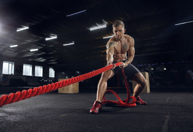 户外年轻健康的男子 运动员在健身房里用绳子锻炼身体单身男模努力练习 锻炼上身健活方式的概念 运动 健身 健美 健康男性强壮运动员