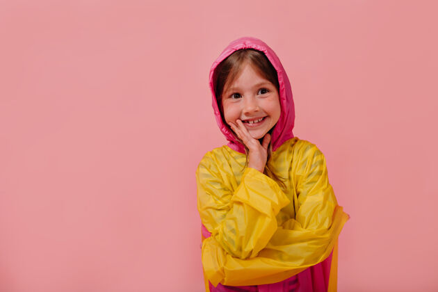 女孩微笑快乐的女孩穿着鲜艳的雨衣微笑着牵着手靠近脸看情绪孩子