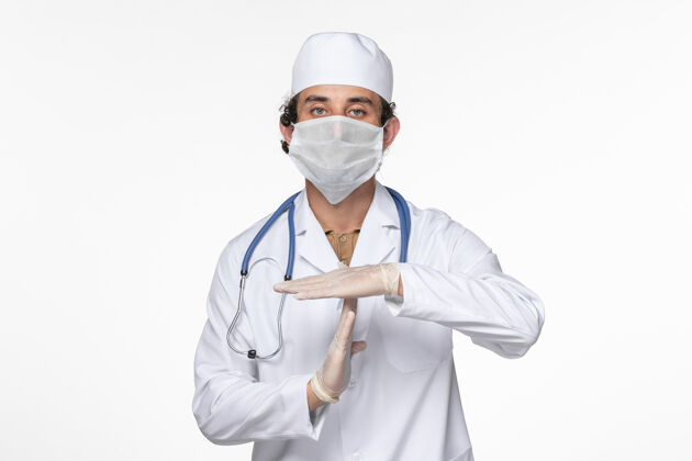 外套正面图男医生穿着医疗服 戴着无菌口罩 以防冠状病毒在白墙上大流行灭菌医疗正面