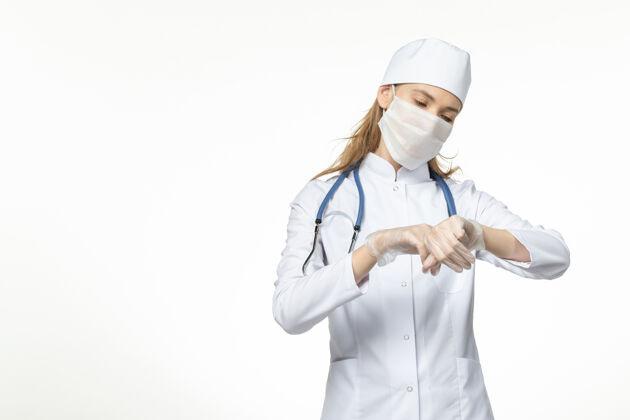 大流行正面图女医生穿着医疗服 戴着口罩和手套 因白色办公桌上的冠状病毒而大流行冠状病毒防护疾病病毒