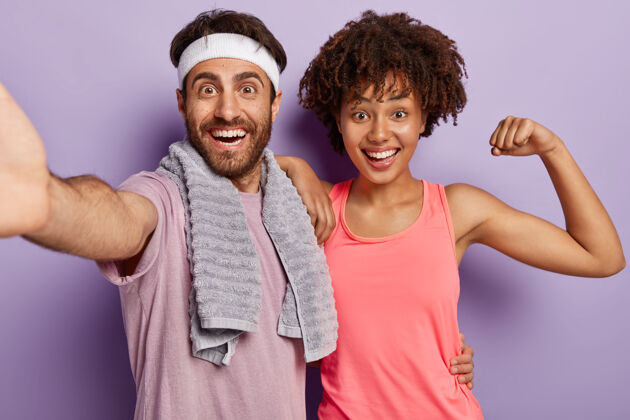 跑步室内拍摄快乐多样的情侣保持肌肉柔韧 每天锻炼身体 穿着运动服站在镜头前开心地看着镜头美国人男性力量