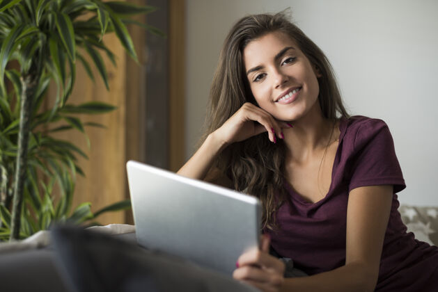 微笑快乐的年轻女子与数字平板电脑手放在头上黑发青年文化